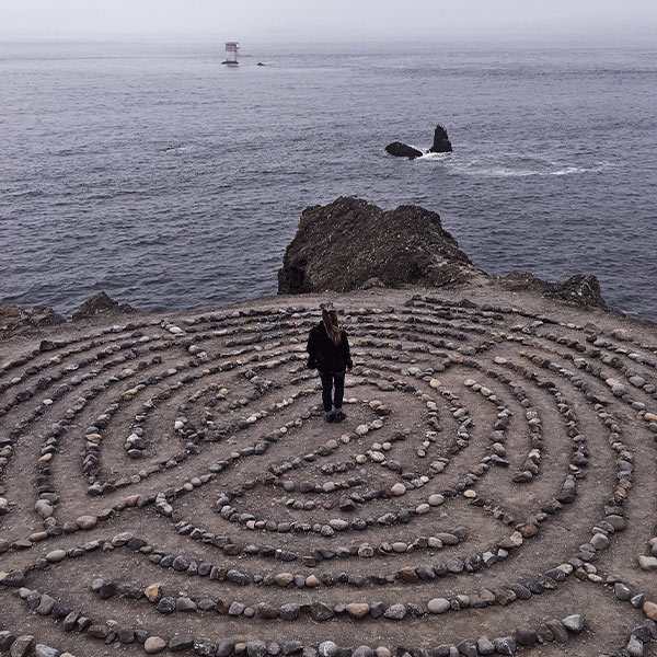 Woman standing by a cliff at the beach